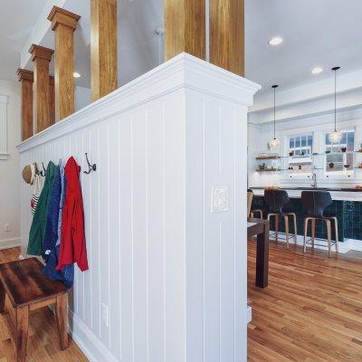 Coats hooks on half wall next to kitchen area Wilcox Architecture